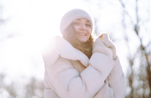 Jonge vrouw in kleding in winterstijl wandelen in het besneeuwde park Wintermodevakanties