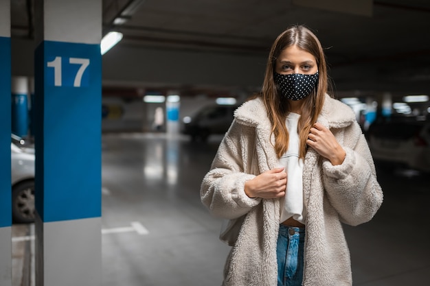 Jonge vrouw in masker bij de ondregroundparking