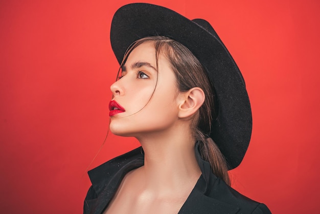 Jonge vrouw in mode hoed. Schoonheid vrouw gezicht portret in studio. Mooi meisje met schone huid, natuurlijke make-up.