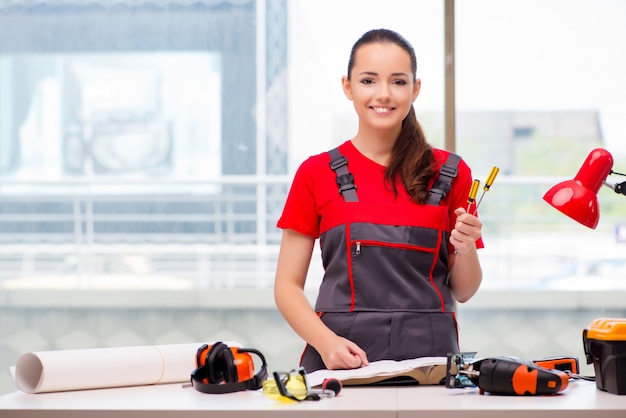 Jonge vrouw in overtrekken die reparaties doen