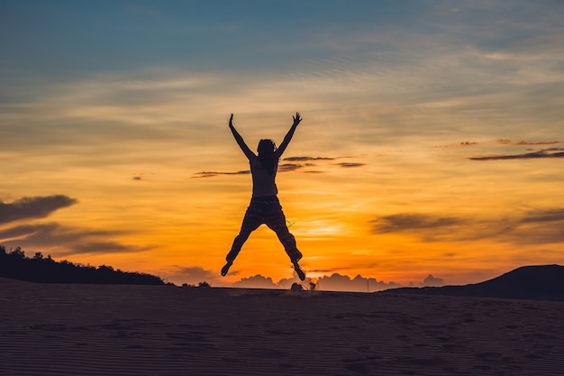 Jonge vrouw in rad zandwoestijn bij zonsondergang