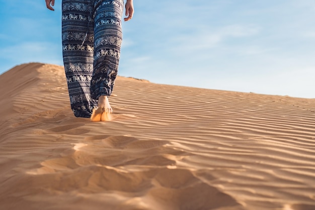 Jonge vrouw in rad zandwoestijn bij zonsondergang