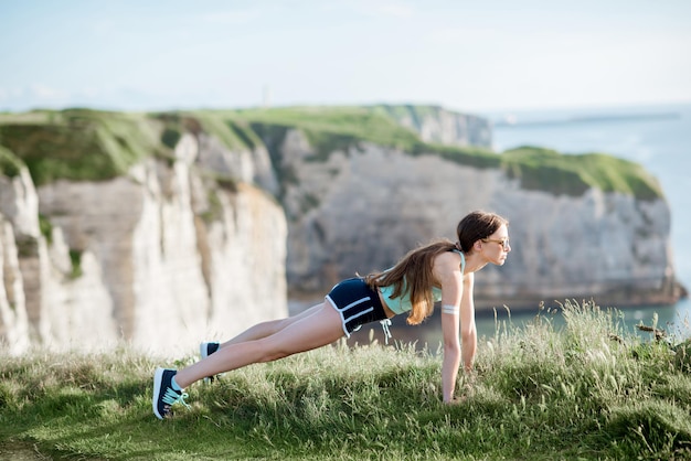 Jonge vrouw in sportkleding die buiten traint op de prachtige rotsachtige achtergrond