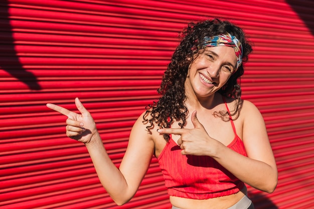 Jonge vrouw in sportkleding die met haar vingers richt.