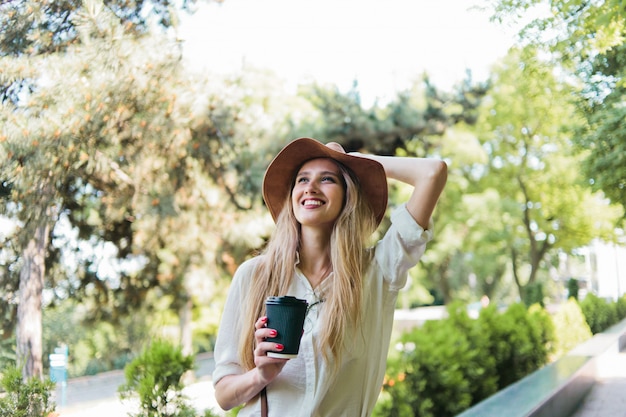 Jonge vrouw in stijlvolle kleding met een kopje koffie