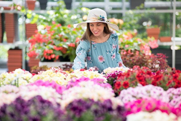 Jonge vrouw in sunhat het kopen installaties bij een kinderdagverblijf