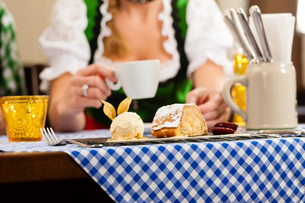 Jonge vrouw in traditionele Beierse klederdracht in restaurant of pub