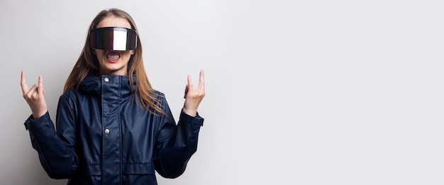 Jonge vrouw in virtual reality-bril toont een rocker-geit op een lichte achtergrond Banner