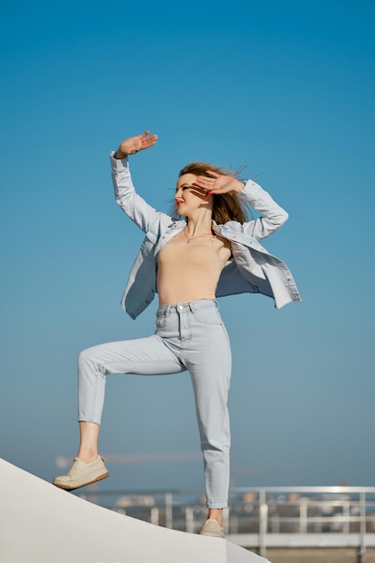 Jonge vrouw in vrijetijdskleding bedekt de ogen van de zon op een winderige dag