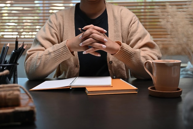 Jonge vrouw in warme trui kijken naar webinar op computer thuis.