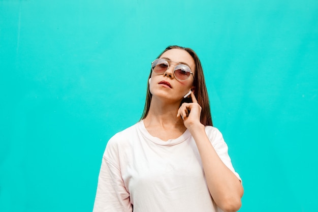 Jonge vrouw in zonnebril met oortelefoons