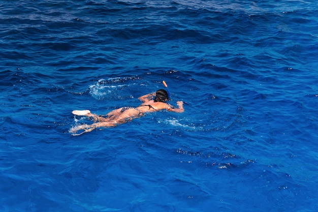 Jonge vrouw in zwembroek snorkelen