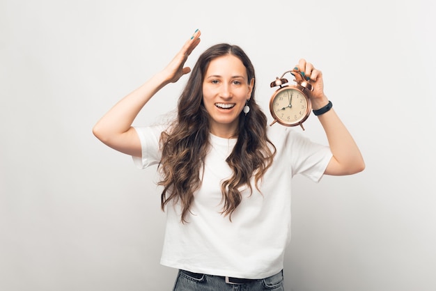 Jonge vrouw is gefrustreerd over de snelheid van de tijd. portret op witte achtergrond.