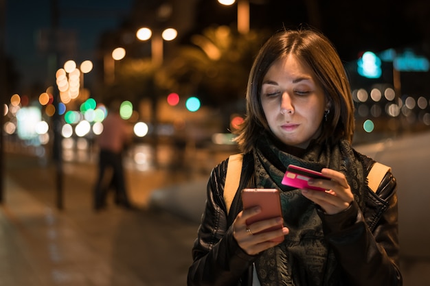 Jonge vrouw is online winkelen met haar smartphone. nieuwe technologieën, levensstijl