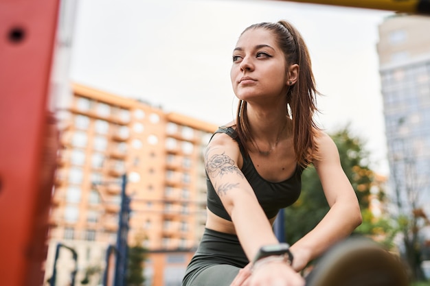 Foto jonge vrouw is 's ochtends bezig met sporten op simulators.