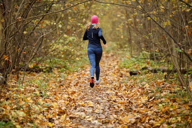 Jonge vrouw joggen in de ochtend in herfst park