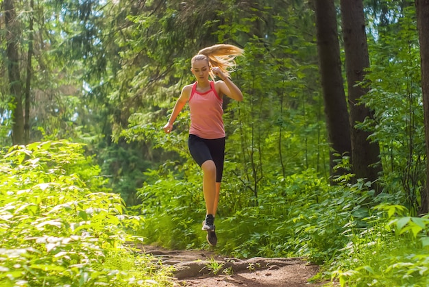 Jonge vrouw joggen op een pad in een bergbos