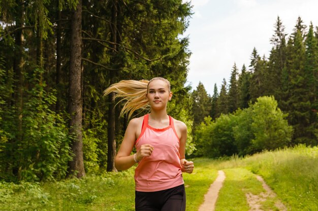 Jonge vrouw joggen op een parcours in het bos