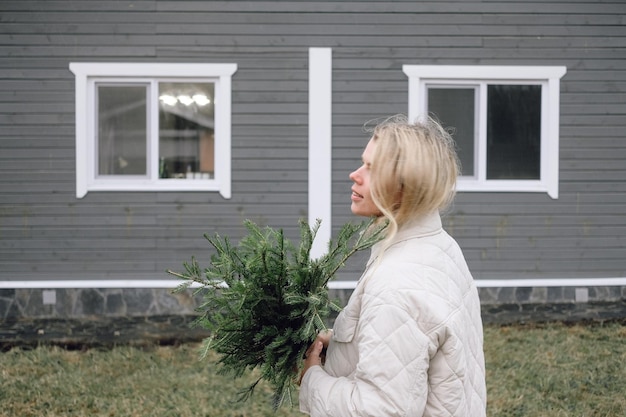 Foto jonge vrouw kerstboom boeket buiten staan