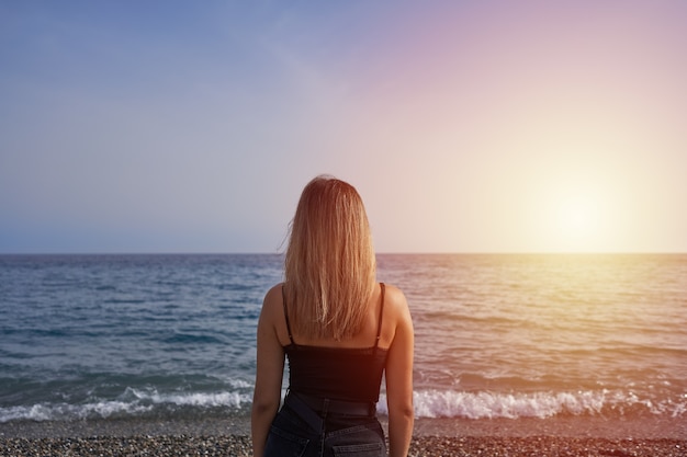 Jonge vrouw kijken naar de horizon in de zee.