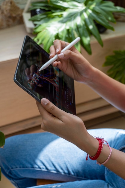 Jonge vrouw kijkt naar de aandelenmarkt op haar tablet terwijl ze op de kaart tekent