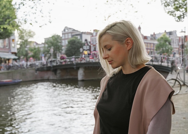 Jonge vrouw kijkt naar een kanaal in de stad