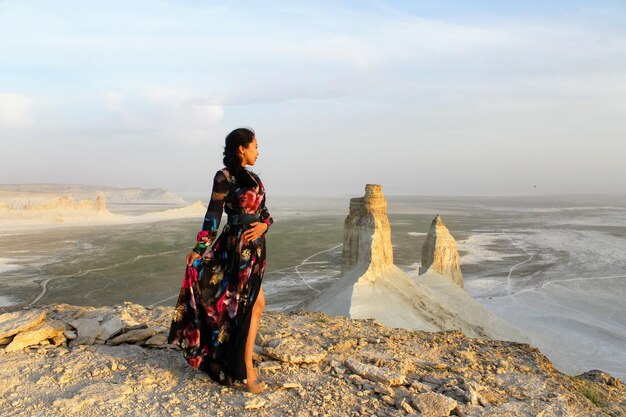 Foto jonge vrouw kijkt naar het landschap