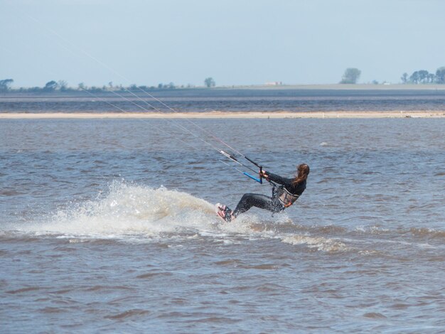 Foto jonge vrouw kitesurft met prachtige golven
