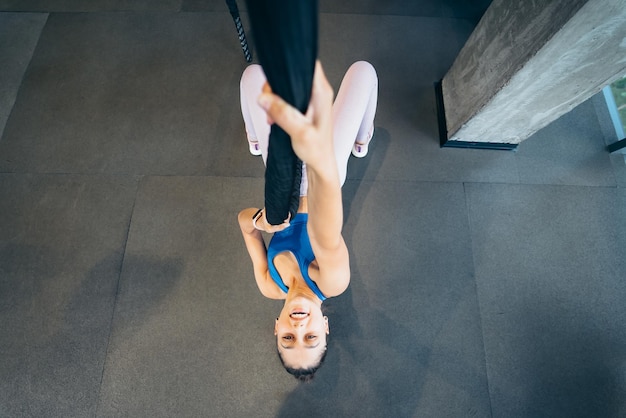 Jonge vrouw klimt een touw in de sportschool