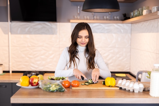 Jonge vrouw koken in de keuken. Gezond eten. Dieet Concept. Gezonde levensstijl. Thuis koken. Eten koken.