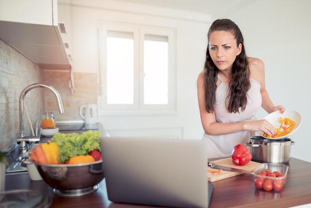 Jonge vrouw koken in de keuken