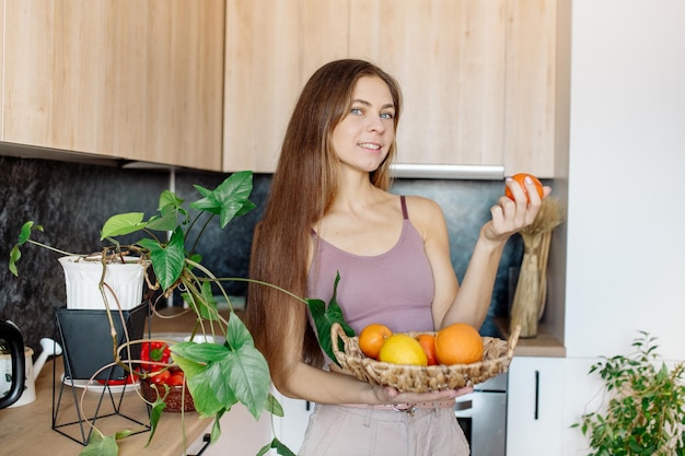 Jonge vrouw kookt in de keuken en maakt thuis een picknick Veganistisch tijdens quarantaine Kamerplanten