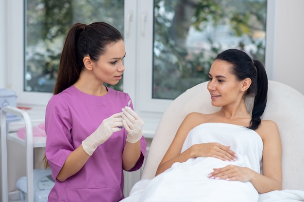 Jonge vrouw krijgt een gezichtsprocedure in een kliniek