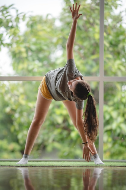 Jonge vrouw leert thuis yoga met behulp van video online training sexy schattig meisje is ontspannen met sport en externe fitness oefening levensstijl binnen thuis geïsoleerd quarantaine thuis concept