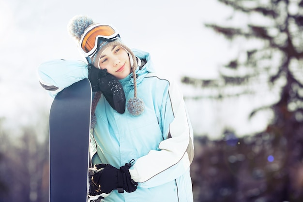 Jonge vrouw leunend op haar snowboard