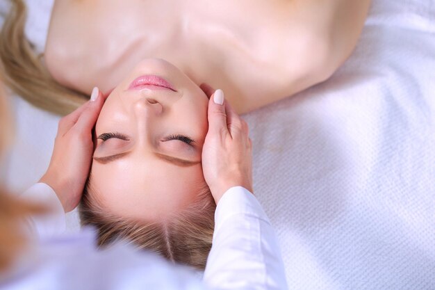 Jonge vrouw liggend op een massagetafel ontspannen met gesloten ogen