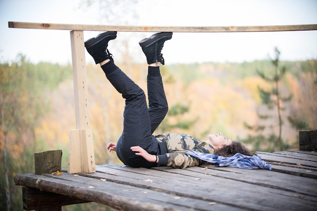 Foto jonge vrouw liggend op een platform op een achtergrond van het bos