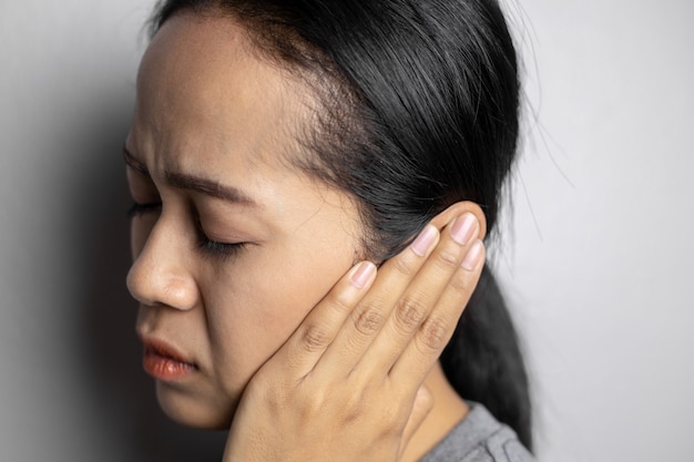 Jonge vrouw lijdt aan oorpijn.