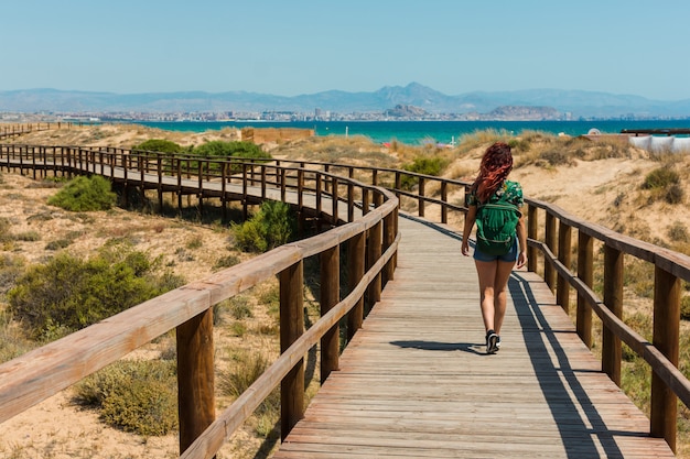 Jonge vrouw loopt door een loopbrug op het strand