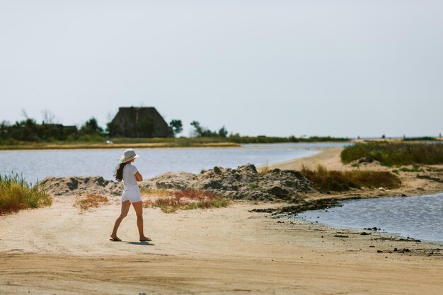 Jonge vrouw loopt langs de kust