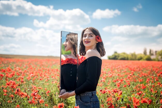 Jonge vrouw lopen op rode papaverveld, zomertijd. Geniet van vrijheid in de natuur