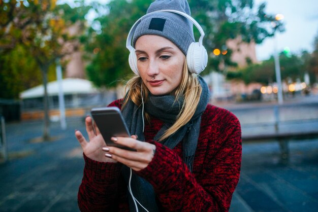 Jonge vrouw, luisteren naar muziek met een smartphone