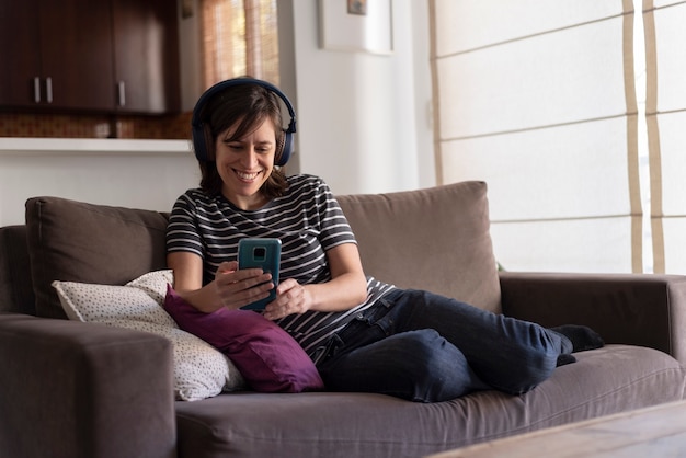 jonge vrouw luisteren naar muziek op koptelefoon met een smartphone