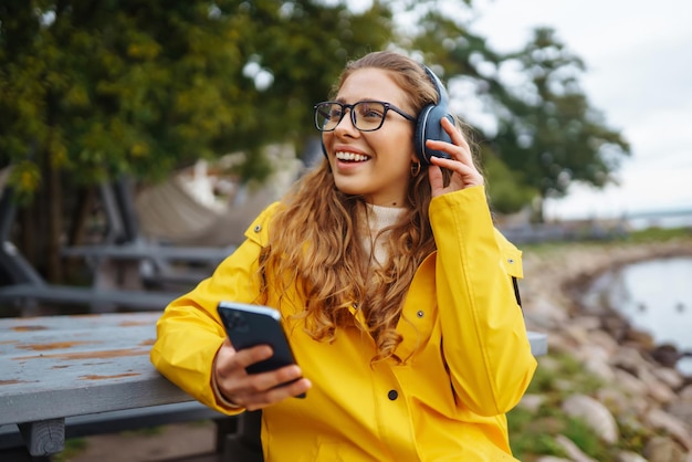 Jonge vrouw luistert naar muziek podcasts buiten Communicatie op sociale netwerken Lifestyle