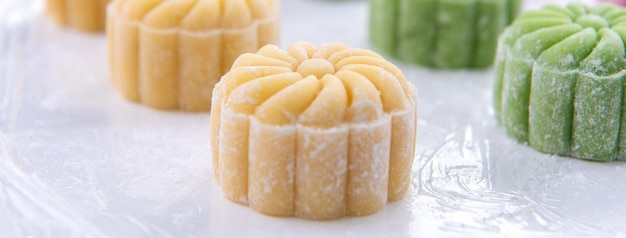 Jonge vrouw maakt kleurrijke sneeuw huid maan cake recept van zoete besneeuwde mooncake traditioneel hartig dessert voor MidAutumn Festival close-up levensstijl