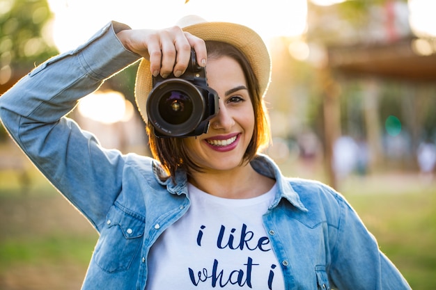 Jonge vrouw maken van foto's met professionele camera in zomer groen park