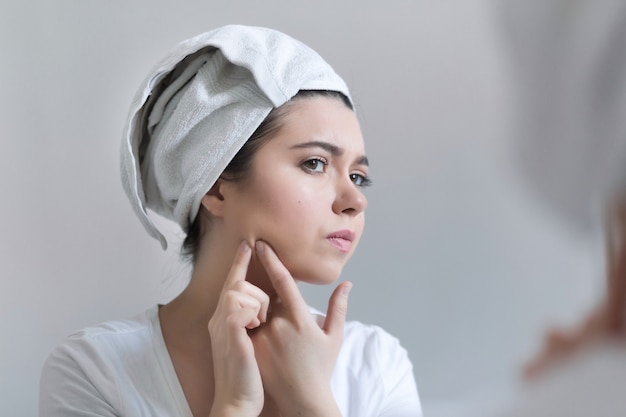 Jonge vrouw met acne in badkamer