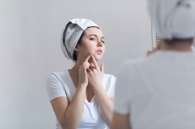 Jonge vrouw met acne in badkamer