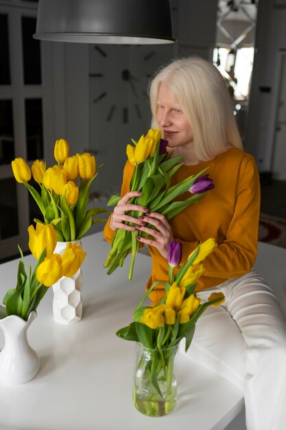 Foto jonge vrouw met albinisme en tulpenbloemen