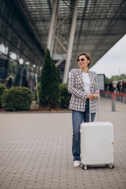 Jonge vrouw met bagage op luchthaven reizen